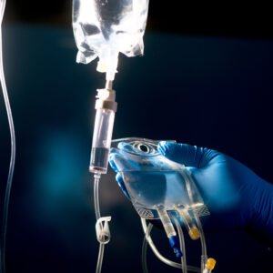 This is a photo of a person hanging an I.V. Bagwitha black background.