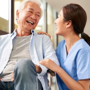 Asian nurse talking to a male nurse who is smiling.