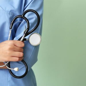 Young nurse with stethoscope on color background, closeup