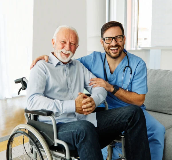 nurse caregiver helping senior man in a wheelchair at home or nursing home