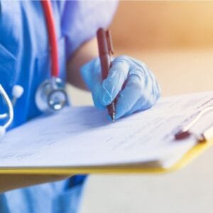 Nurse holding Clip board and pen with blue scrubs